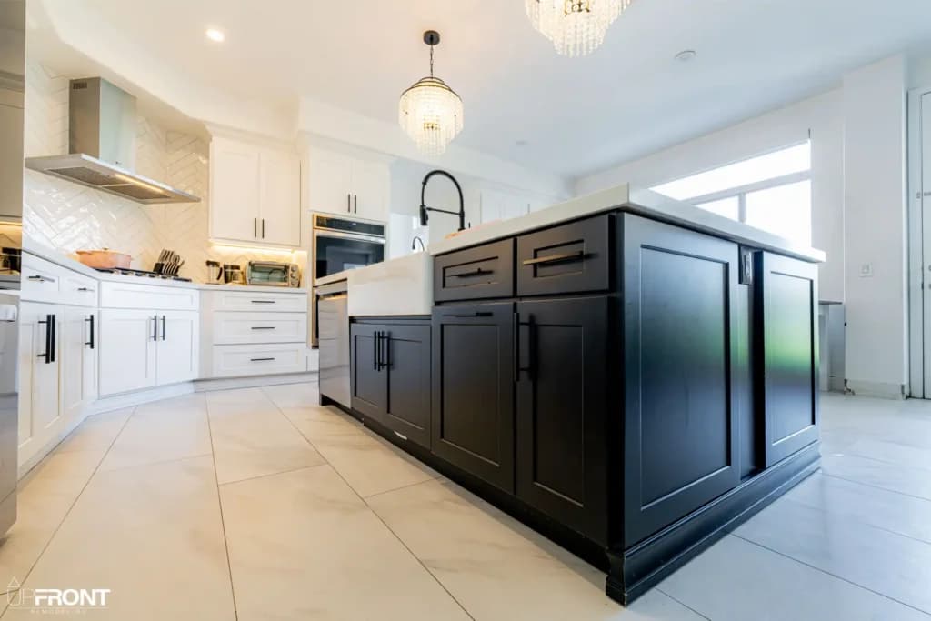 Black-and-white kitchen and bathroom remodel in Moorpark, with white shaker cabinetry and a black island — photo 9 of 18