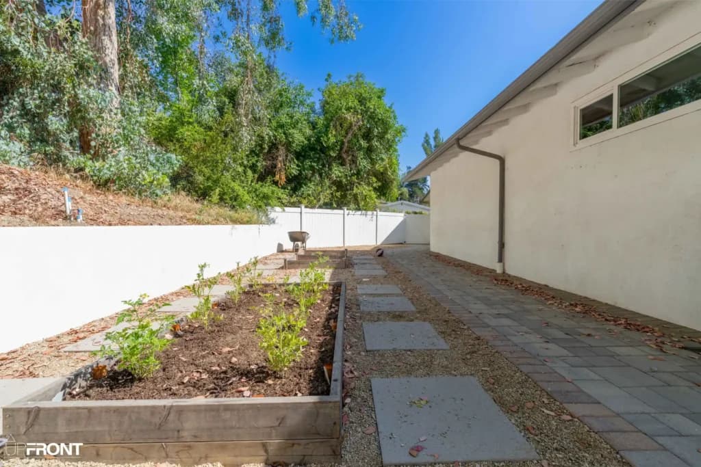 Resort-style backyard remodel in Tarzana, with a freeform pool, paver deck and louvered white pergola — photo 7 of 20