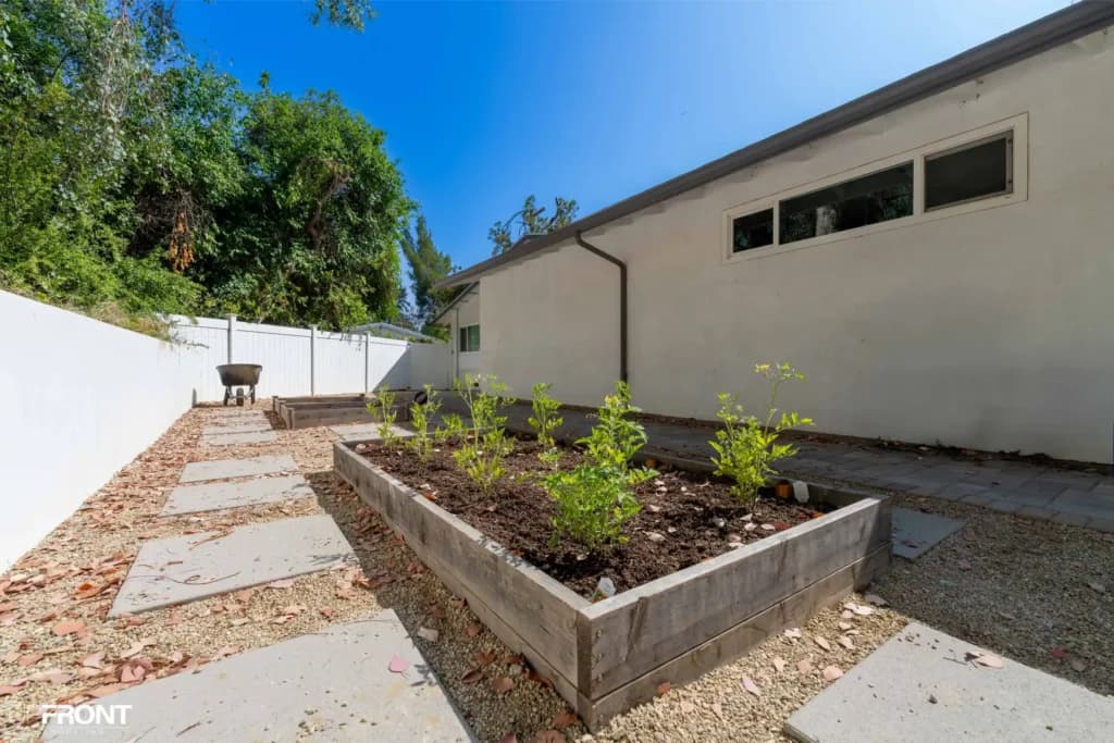 Resort-style backyard remodel in Tarzana, with a freeform pool, paver deck and louvered white pergola — photo 8 of 20