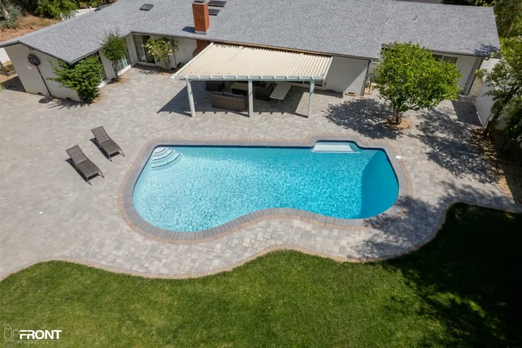 Resort-style backyard remodel in Tarzana, with a freeform pool, paver deck and louvered white pergola — photo 15 of 20