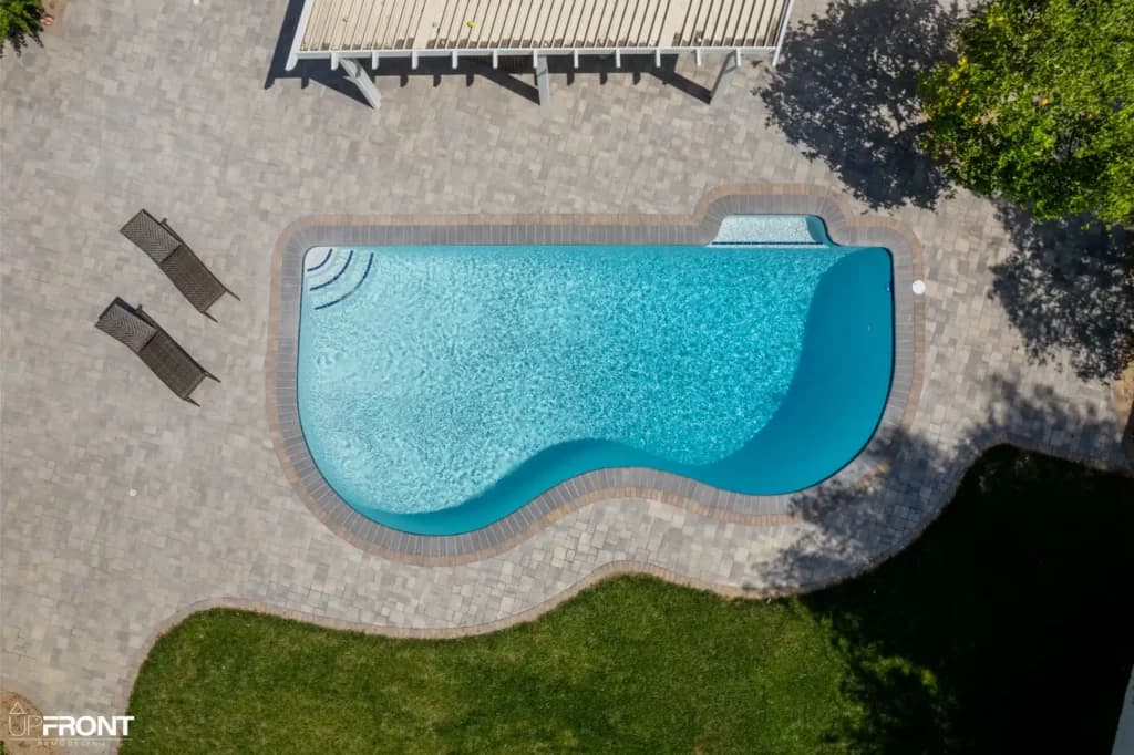 Resort-style backyard remodel in Tarzana, with a freeform pool, paver deck and louvered white pergola — photo 16 of 20